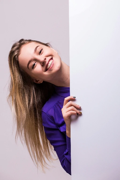 beautiful woman holding blank billboard isolated white wall