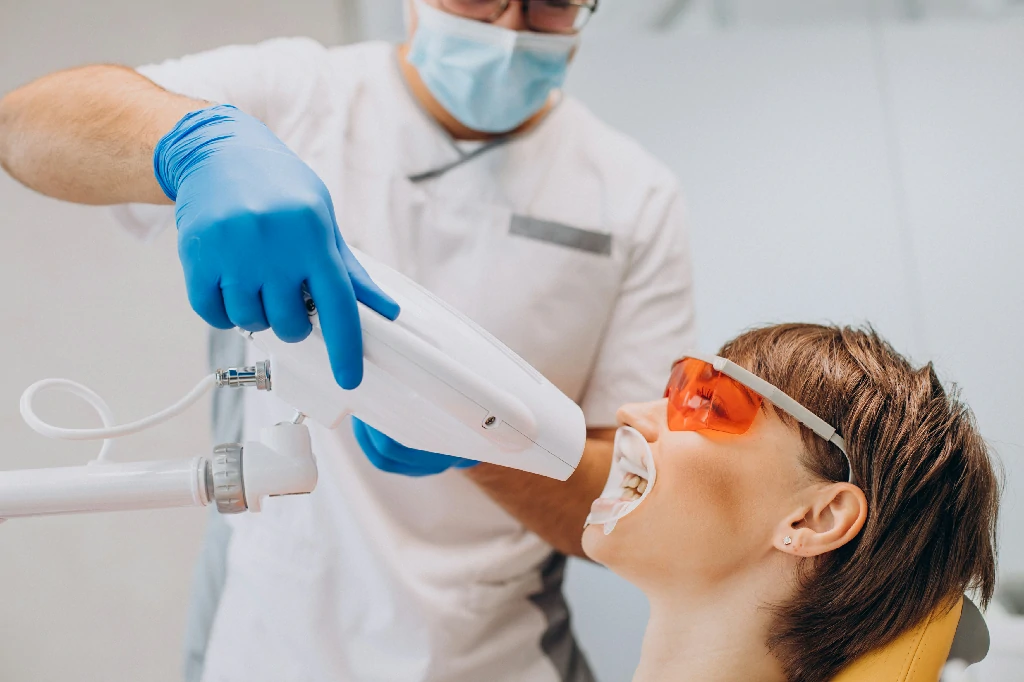 woman whitening teeth dentistry with special equipment 1