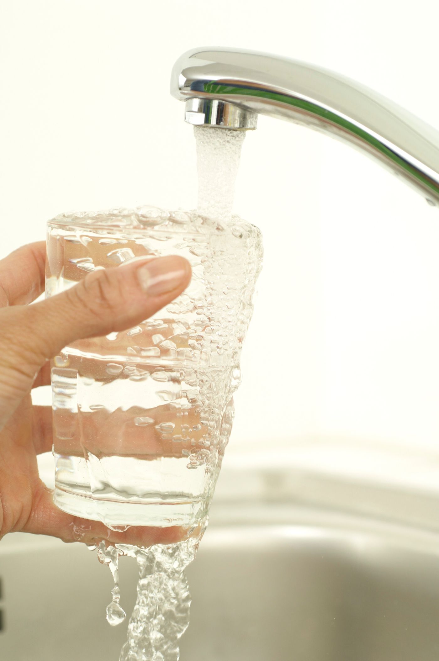 Glass being filled with tap water, illustrating community water fluoridation levels in Anaheim