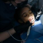Pediatric dentist checking a child's teeth during a back-to-school dental checkup
