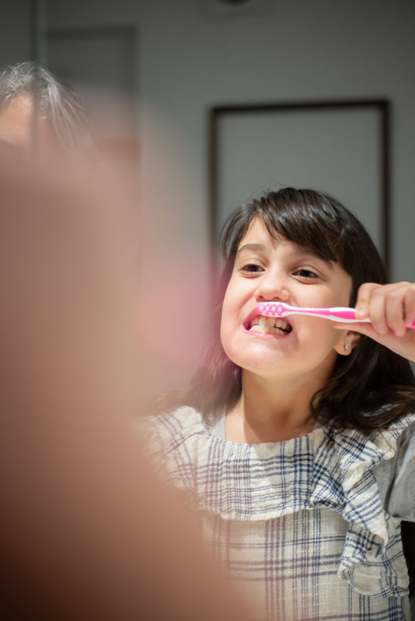 Young girl brushing her teeth using a pea-sized amount of toothpaste
