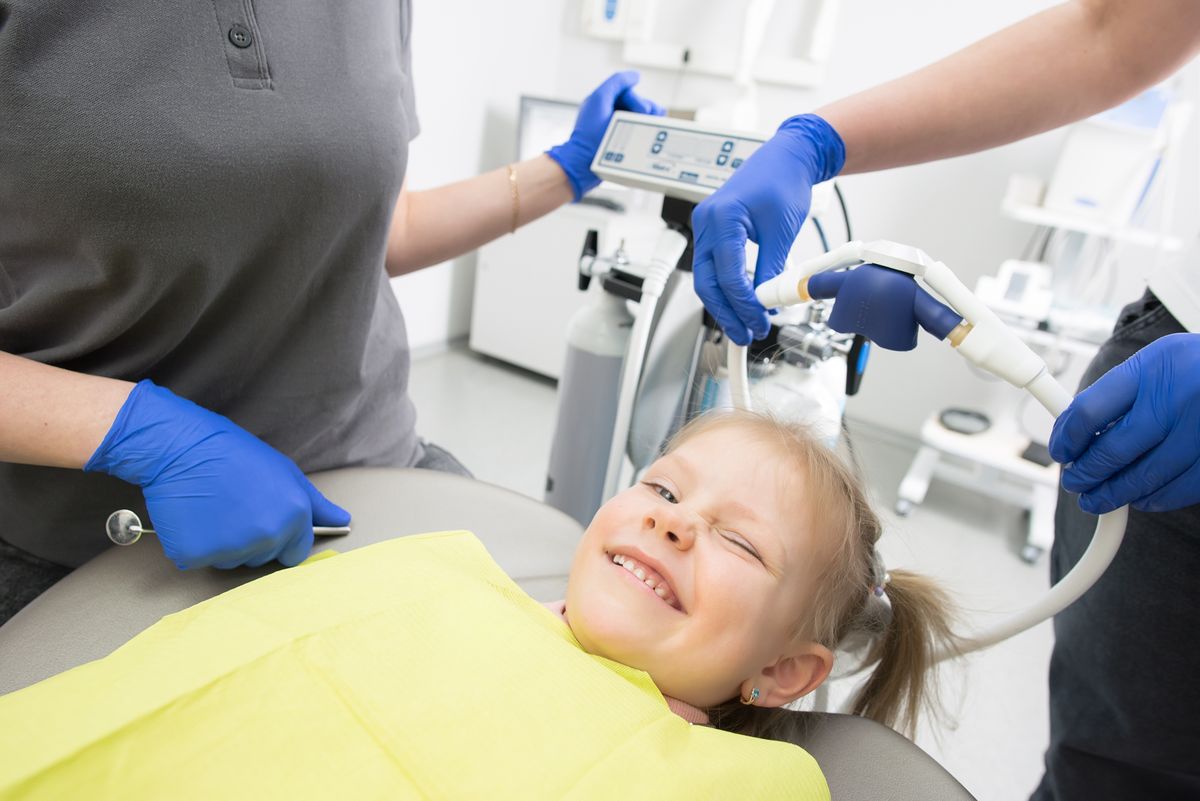 Child smiling in the dental chair before a back-to-school checkup