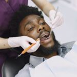 Dentist checking a patient for gum disease and stroke risk during a routine dental exam